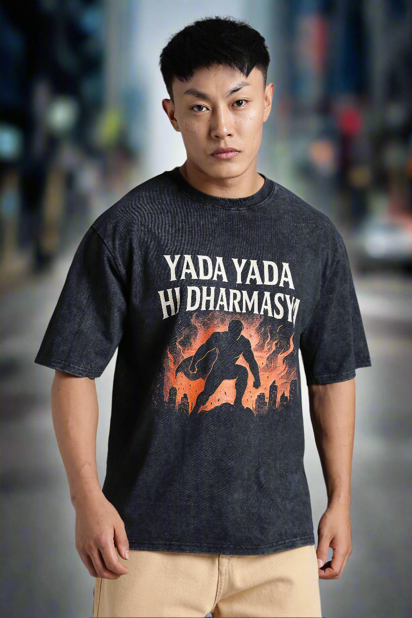 Person wearing a black t-shirt with a graphic design and text on a gray background