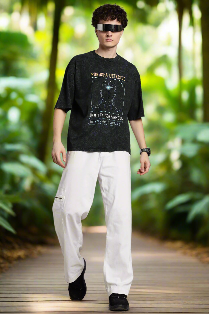 Oversized acid wash black T-shirt with “Purusha Detected” text. Inspired by Vedic philosophy, in dark grey charcoal tones for a bold, streetwear look.