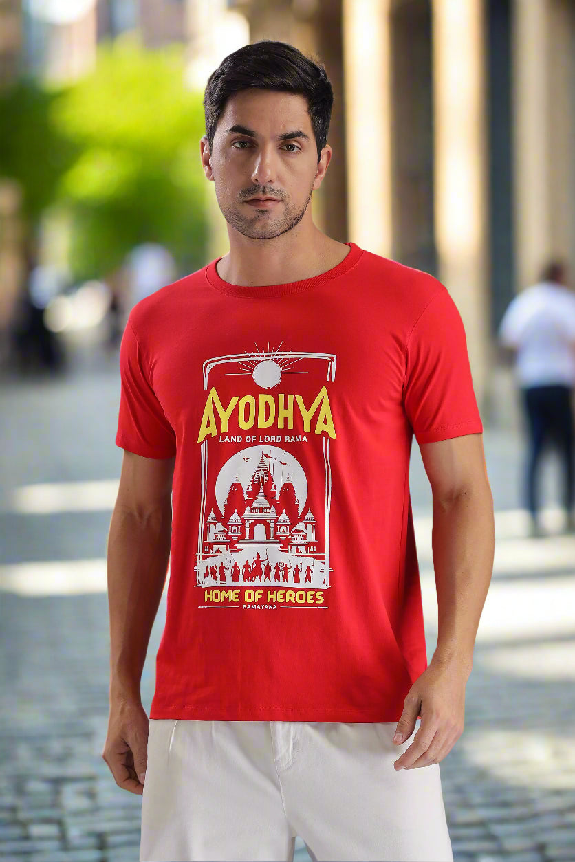 Ayodhya themed red graphic T-shirt featuring Ramayana-inspired temple artwork and 'Home of Heroes' text, worn by a male model on a cobblestone street – EpicThreadsIndia spiritual streetwear